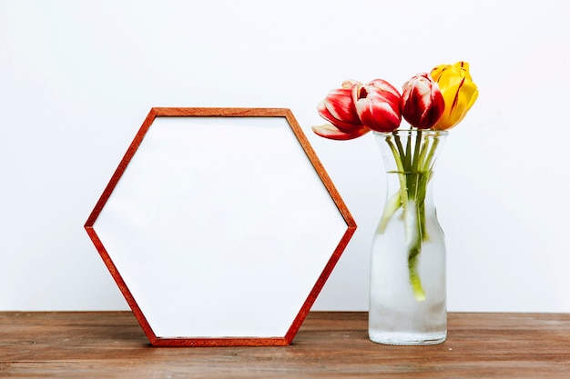 Foto gratuita marco hexagonal cerca de flores en florero