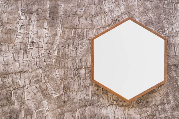 Marco hexagonal de madera blanco en pared pintada