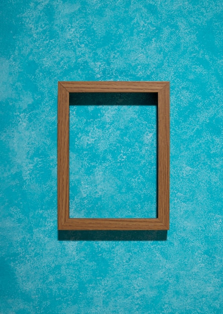 Foto gratuita marco de madera plano sobre fondo azul.