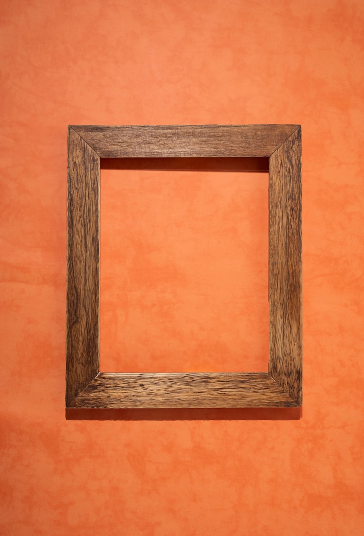 Foto gratuito un marco de madera viejo y plano sobre un fondo naranja