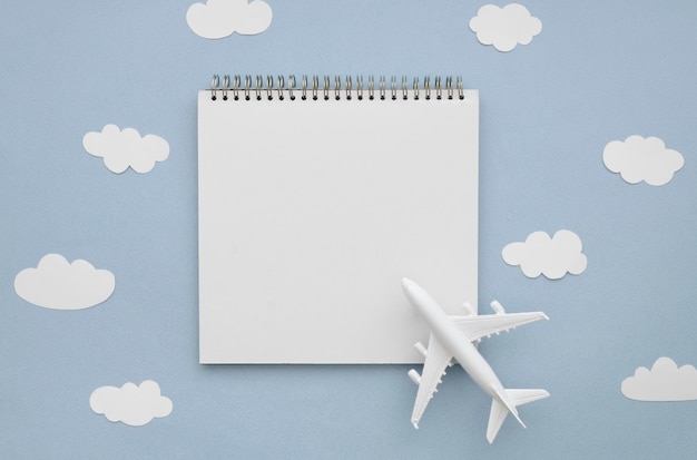 Foto gratuita marco de nubes con avión y cuaderno
