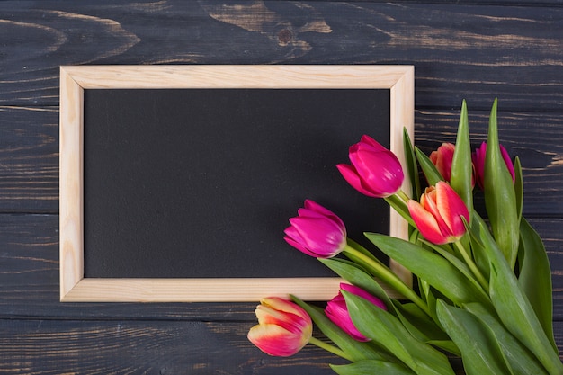 Foto gratuita marco de pizarra con flores