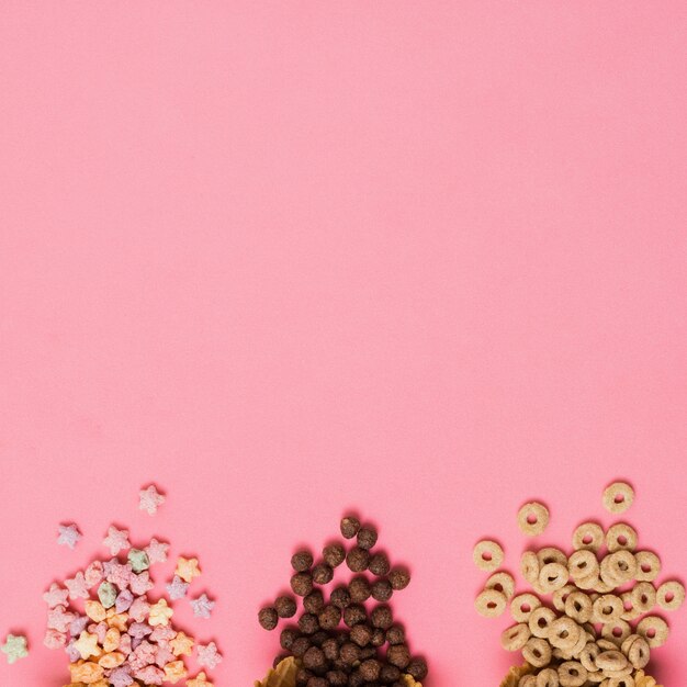 Marco plano laico con cereales sobre fondo rosa