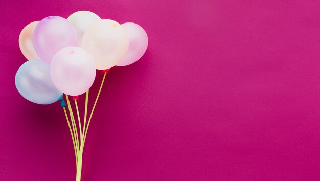 Marco plano laico con globos y fondo rosa