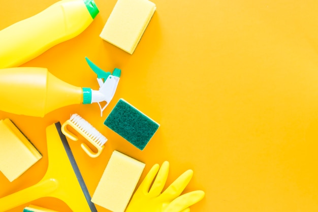 Marco plano con productos de limpieza amarillos y fondo