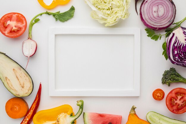 Marco vacío blanco con arreglo de verduras