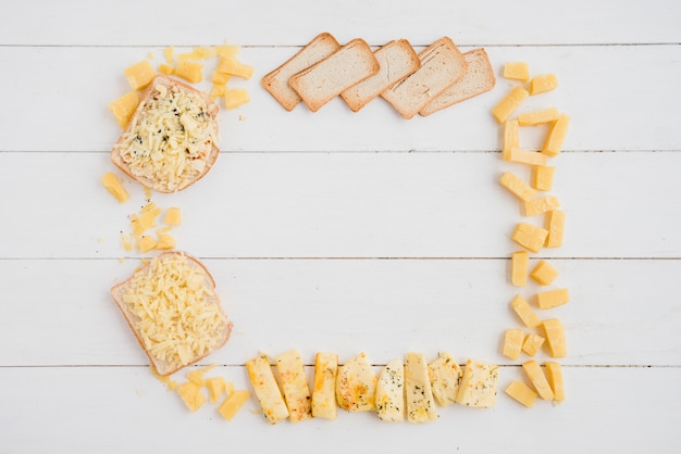 Un marco vacío hecho con queso y pan en el escritorio blanco