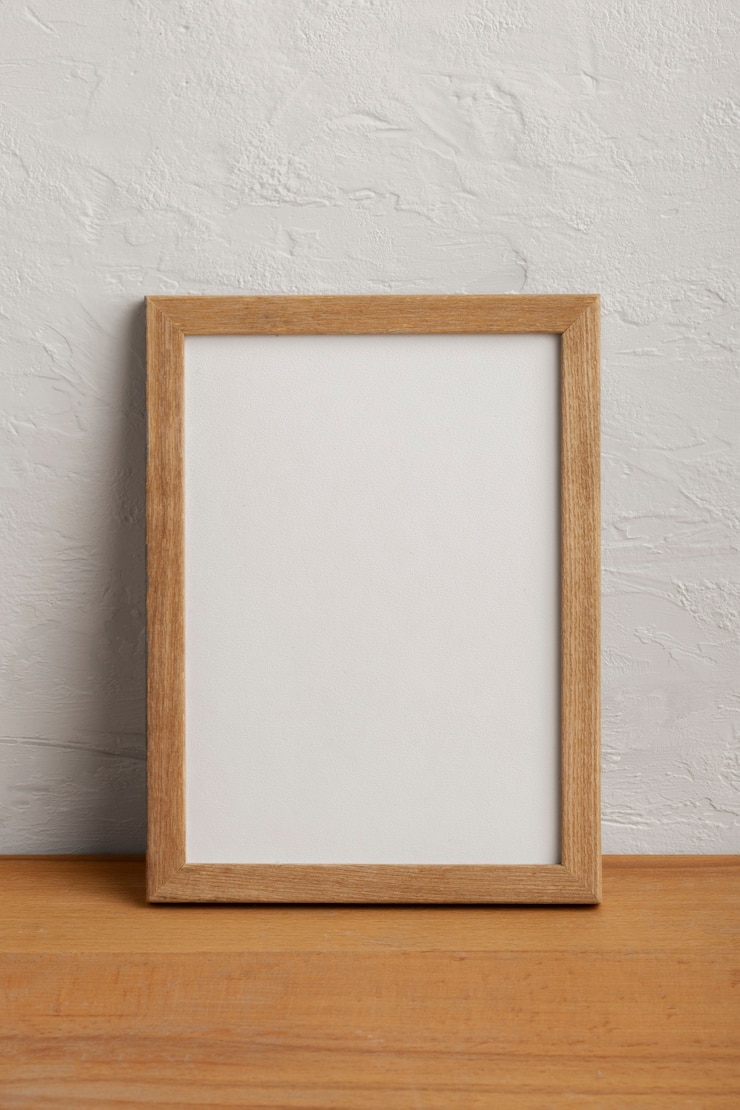 Foto gratuito marco vacío de madera con pared blanca.
