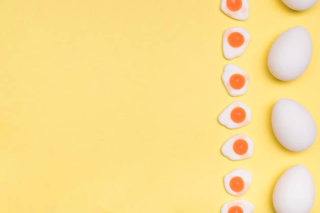 Foto gratuita marco de vista superior con huevos y fondo amarillo