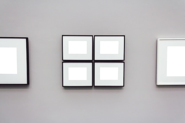 Marcos cuadrados blancos en blanco unidos a una pared gris