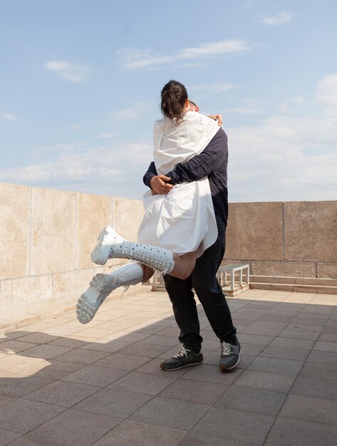 Marido abrazando a la esposa pasando el aniversario de la relación en la terraza de la torre disfrutando de la vista panorámica de la ciudad metropolitana. Hermoso paisaje de edificios de la ciudad. Azotea romántica