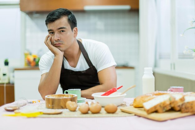 Marido aburrido preparando el desayuno concepto de ideas familiares en casa