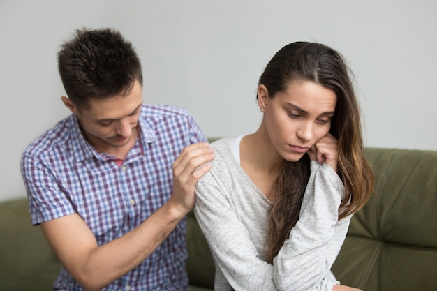 Marido apoyando reconfortante molesta esposa deprimida, concepto de infertilidad y simpatía