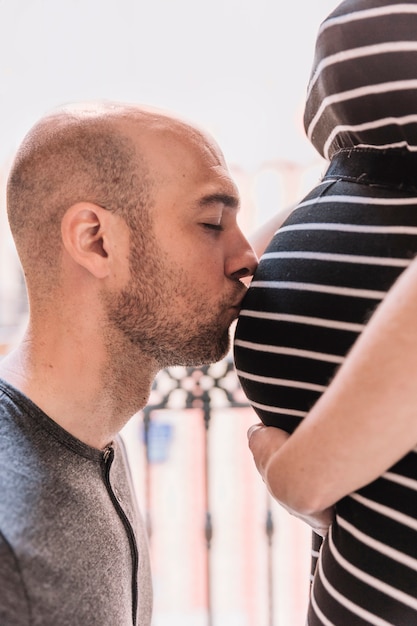 Foto gratuita marido besando mujer embarazada