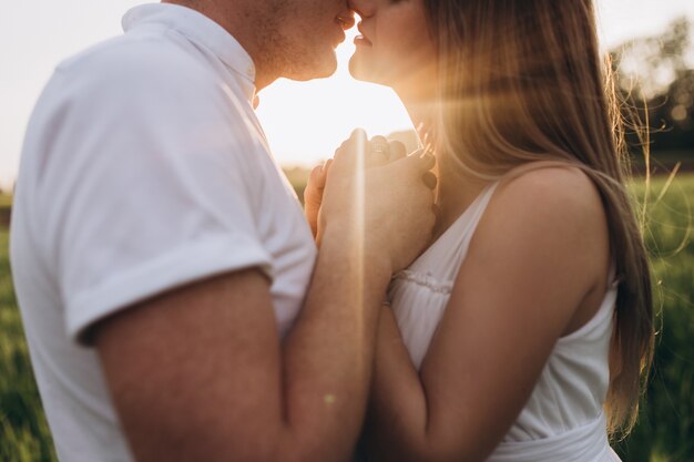 El marido besando a su esposa y parado en el campo