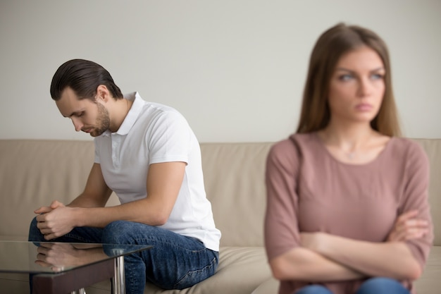 Foto gratuita el marido deprimido triste ofendió a la esposa en la pelea, sintiéndose culpable culpable