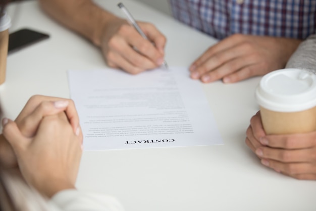 Marido firma contrato de compra de vivienda.