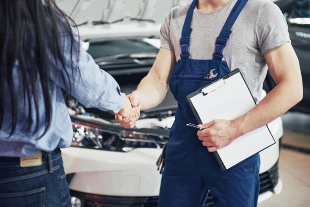 marido mecánico de automóviles y clienta hacen un acuerdo sobre la reparación del automóvil