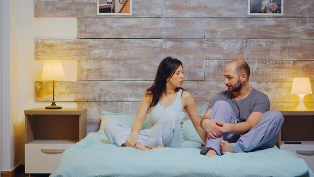 Marido y mujer alegres en pijama y tener una conversación. Feliz matrimonio.