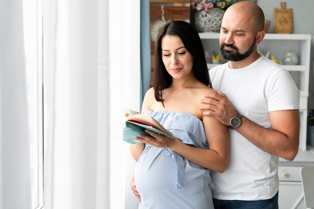Marido y mujer embarazada buscando nombres para bebés