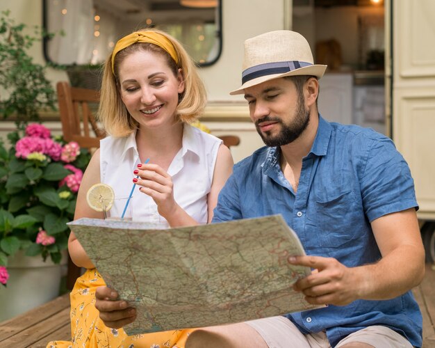 Marido y mujer mirando un mapa junto a su caravana