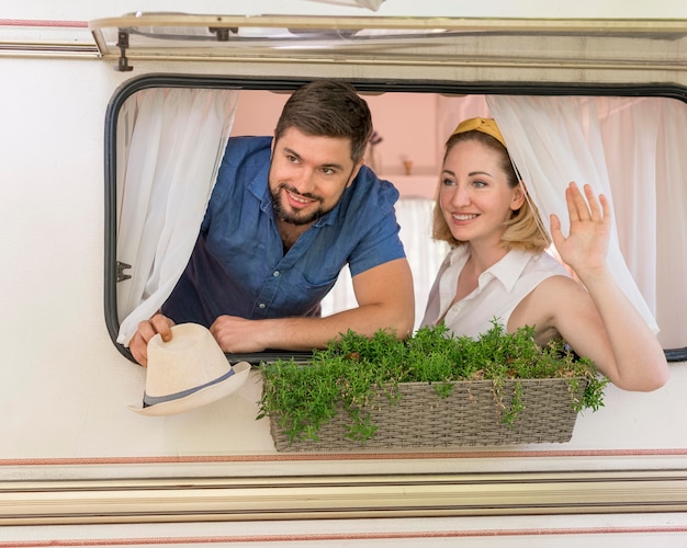 Marido y mujer mirando por la ventana de una caravana