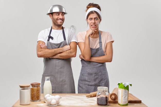 Marido y mujer posan en la cocina preparando una sabrosa cena