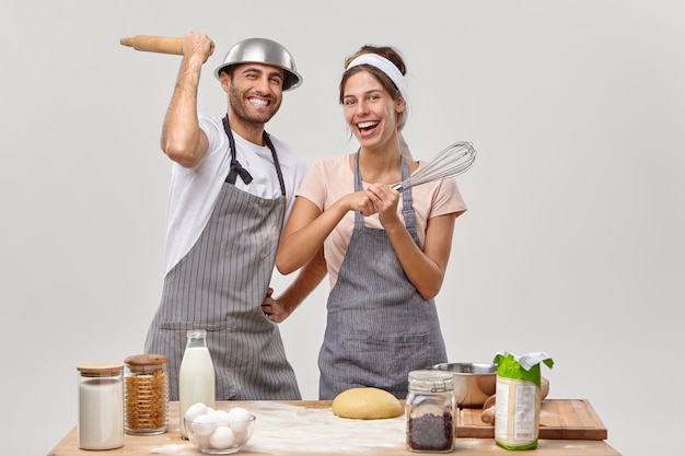 Marido y mujer posan en la cocina preparando una sabrosa cena