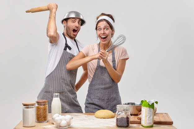 Marido y mujer posan en la cocina preparando una sabrosa cena