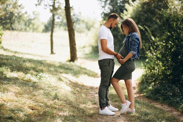 Marido con su esposa embarazada caminando en el parque