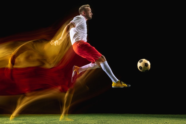 Más alto. Jugador de fútbol o fútbol masculino caucásico joven en ropa deportiva