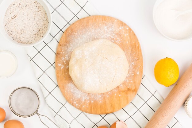 Masa amasada con ingrediente saludable y utensilio de cocina.