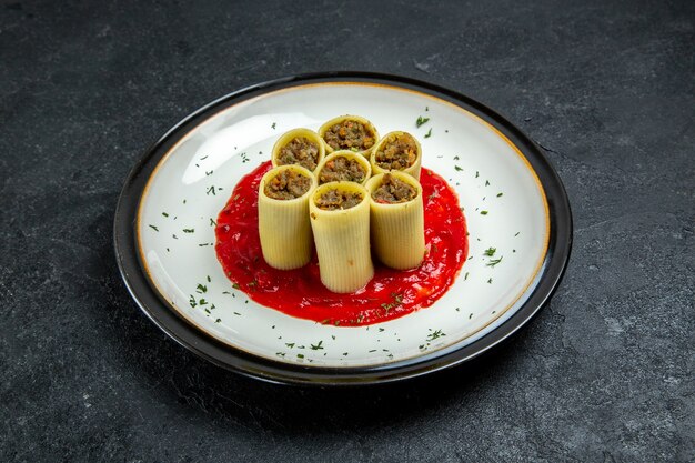 Masa de vista frontal con rodajas de carne en rodajas con salsa de tomate en el espacio gris