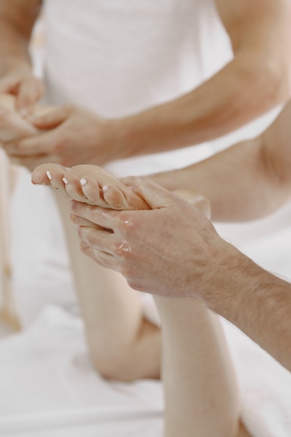 Foto gratuita el masaje a cuatro manos. concepto de salud y belleza femenina. dos masajistas hacen un doble masaje a una chica. mujer en un salón de spa.