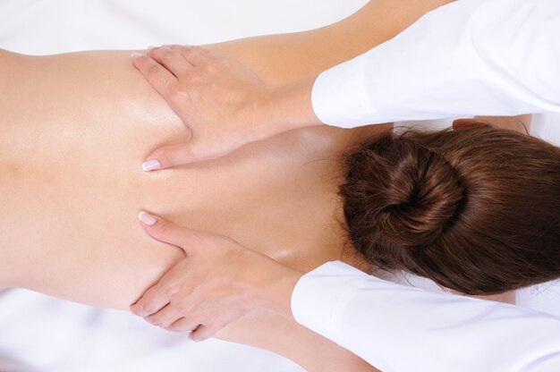 Masaje de espalda saludable para la mujer joven - fondo blanco