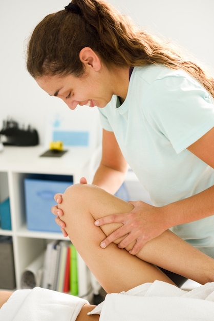 Masaje médico en la pierna en un centro de fisioterapia.