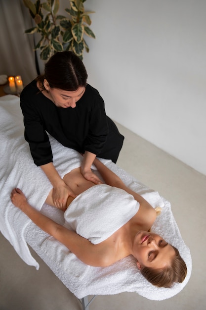 Foto gratuita masajista femenina dando masaje de espalda al cliente