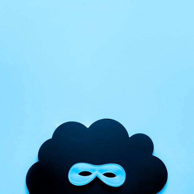 Máscara de carnaval azul en nube de papel negro con espacio de copia