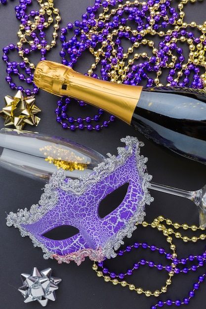 Máscara de carnaval con champaña y joyas.