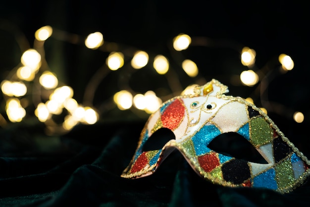 Foto gratuita máscara de carnaval frente a luces borrosas