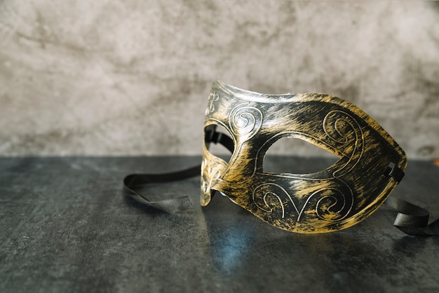 Máscara elegante con pintura dorada y negra.
