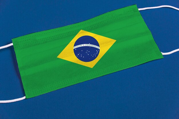 Máscara quirúrgica sobre fondo azul con bandera brasileña