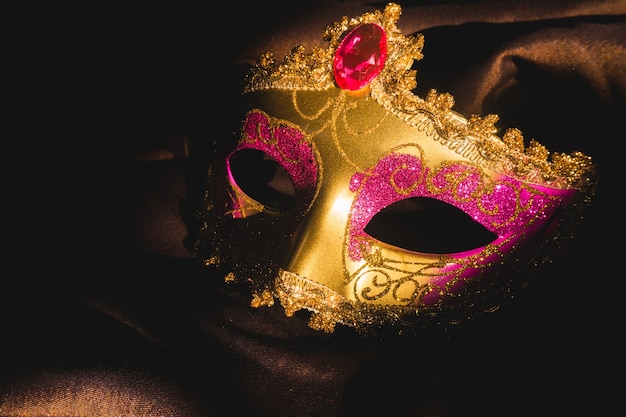 Máscara veneciana dorada con un fondo oscuro