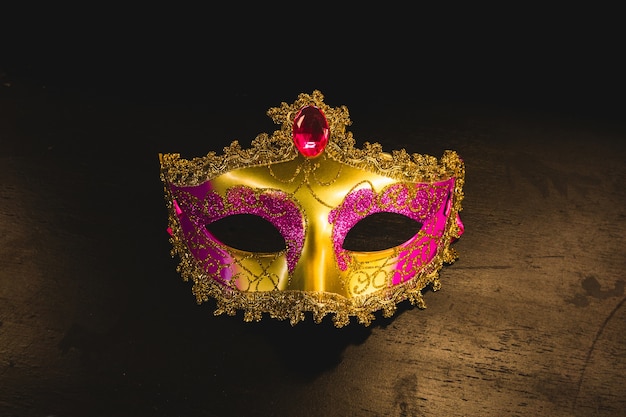 Máscara veneciana dorada sobre una mesa de madera
