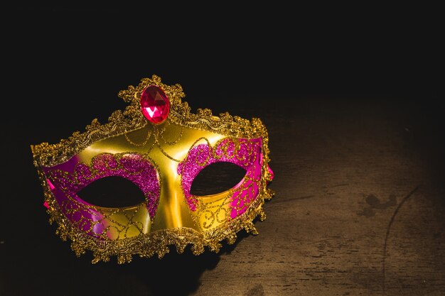 Máscara veneciana dorada sobre una mesa de madera