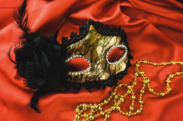 Máscara veneciana dorada sobre una tela roja