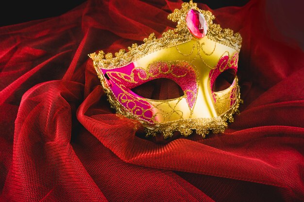 Máscara veneciana dorada sobre una tela roja