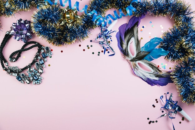 Mascarada carnaval máscara de plumas con material de decoración brillante sobre fondo rosa