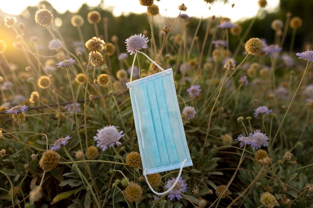 Foto gratuita mascarilla en campo de flores.