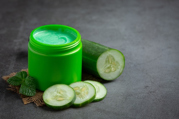 Mascarilla con rodajas de pepino sobre fondo oscuro